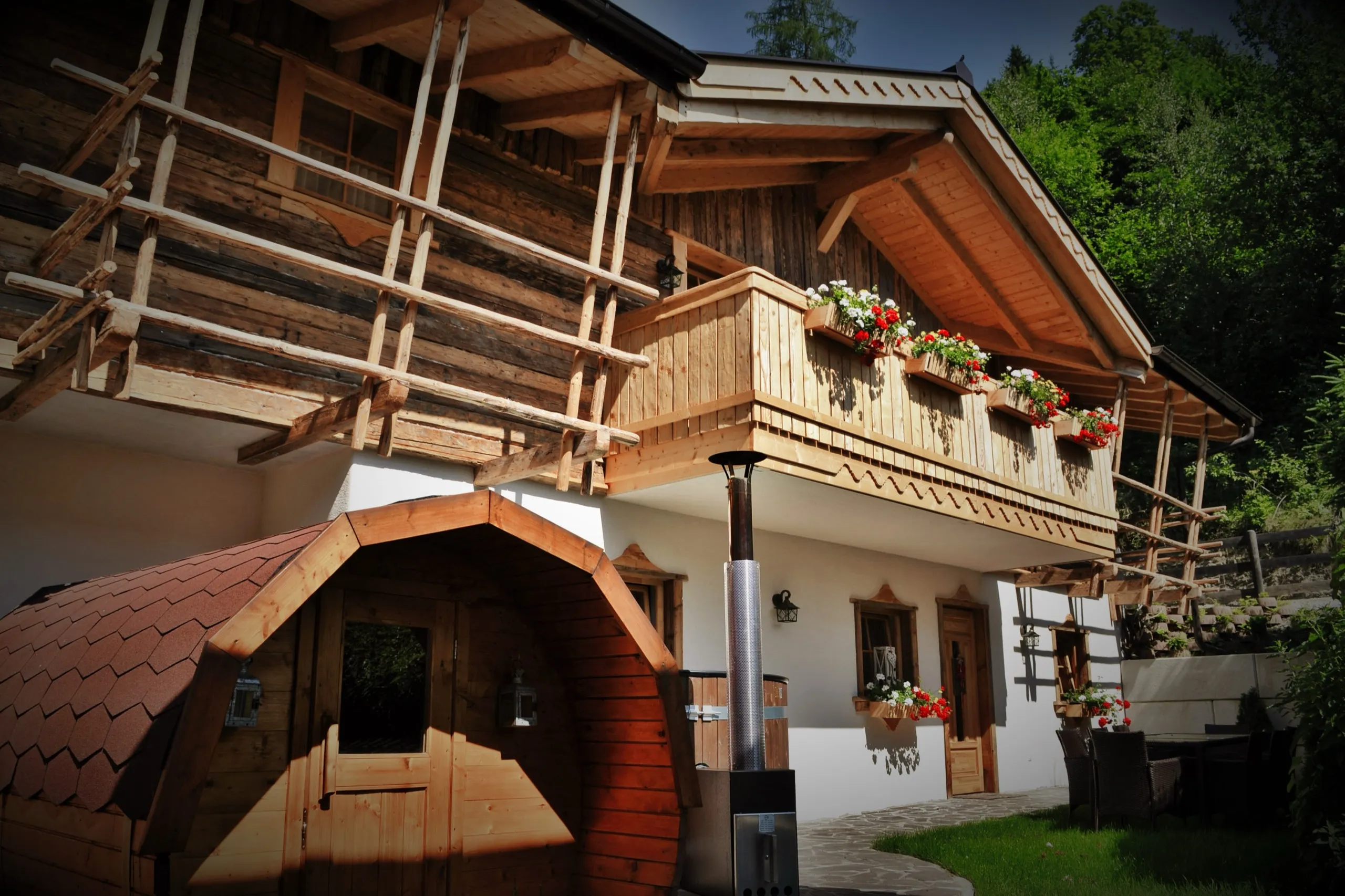 Holzbalkon mit Blumenkästen in der Abendsonne