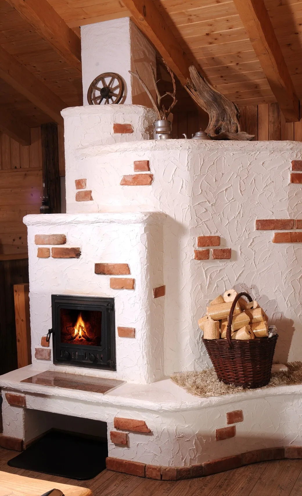 Weißer Kachelofen mit brennendem Feuer und Holzkorb