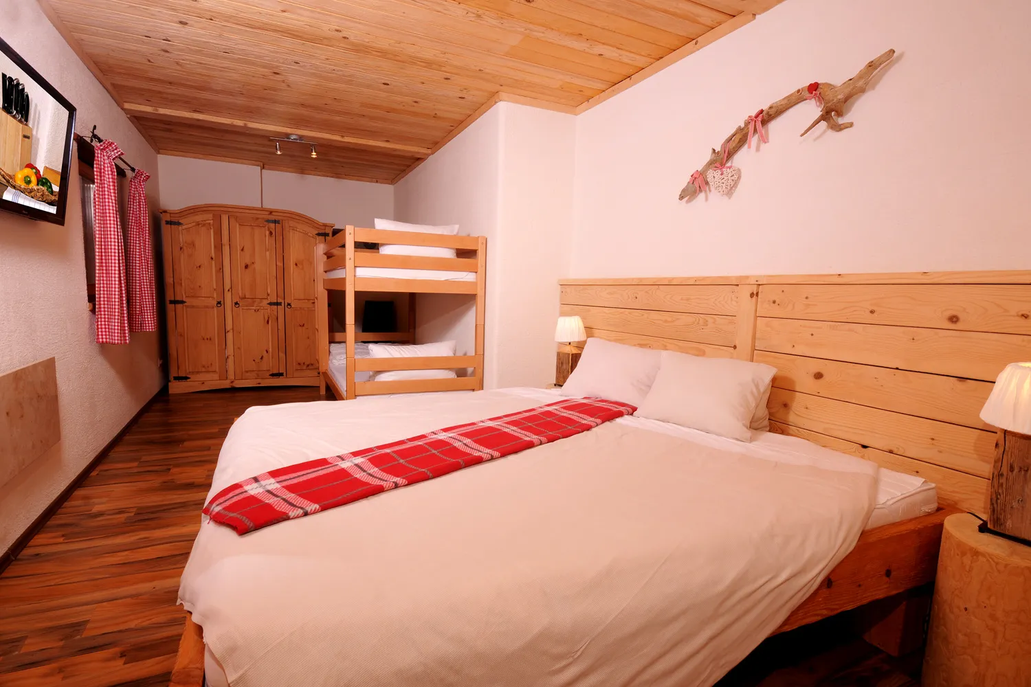 Schlafzimmer mit Doppelbett und Etagenbett im Almchalet Dorfblick
