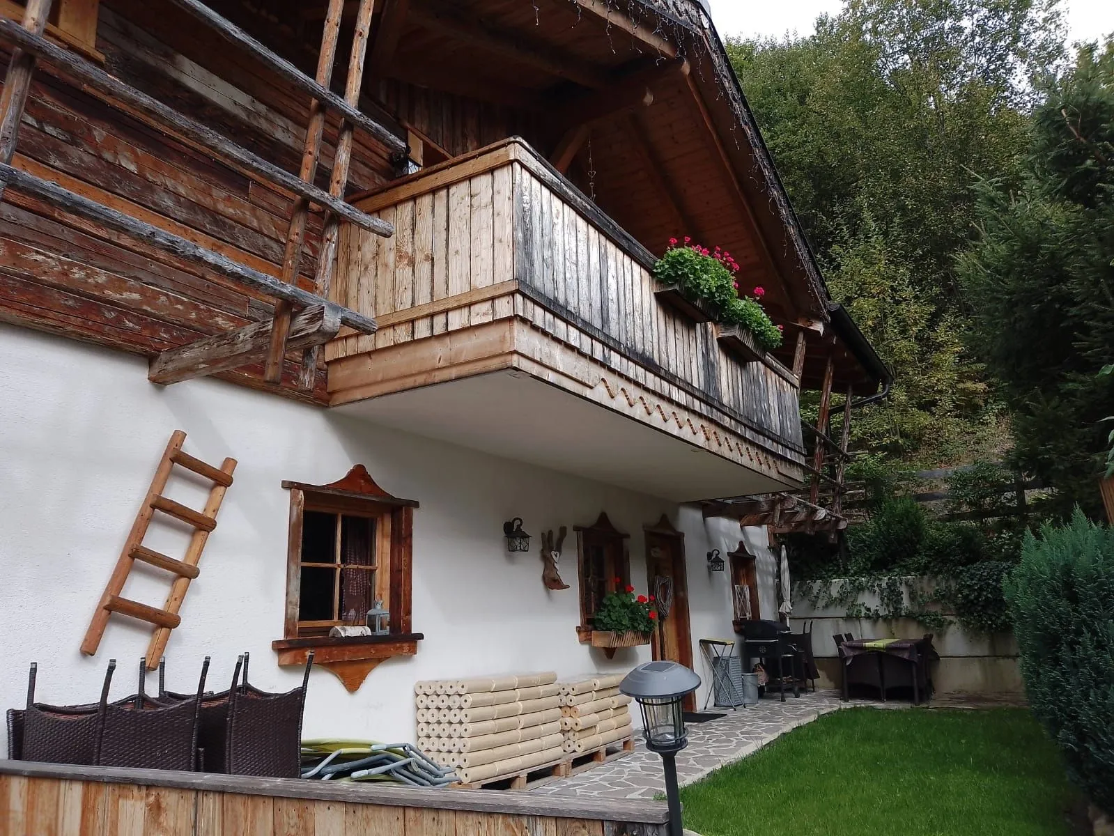 Almchalet Dorfblick mit Holzbalkon, Blumenkästen und Terrasse im Sommer