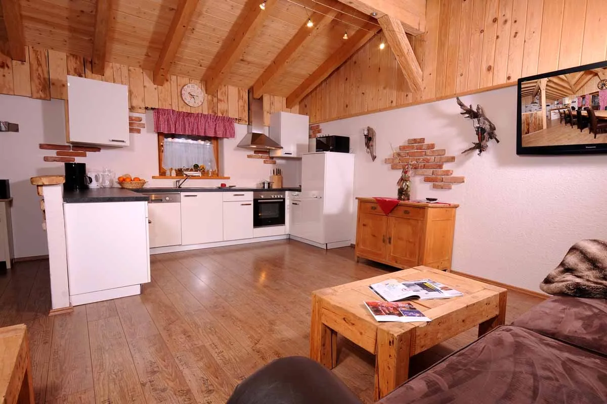 Offene Küche mit Wohnbereich und Holzdecke im Almchalet Dorfblick