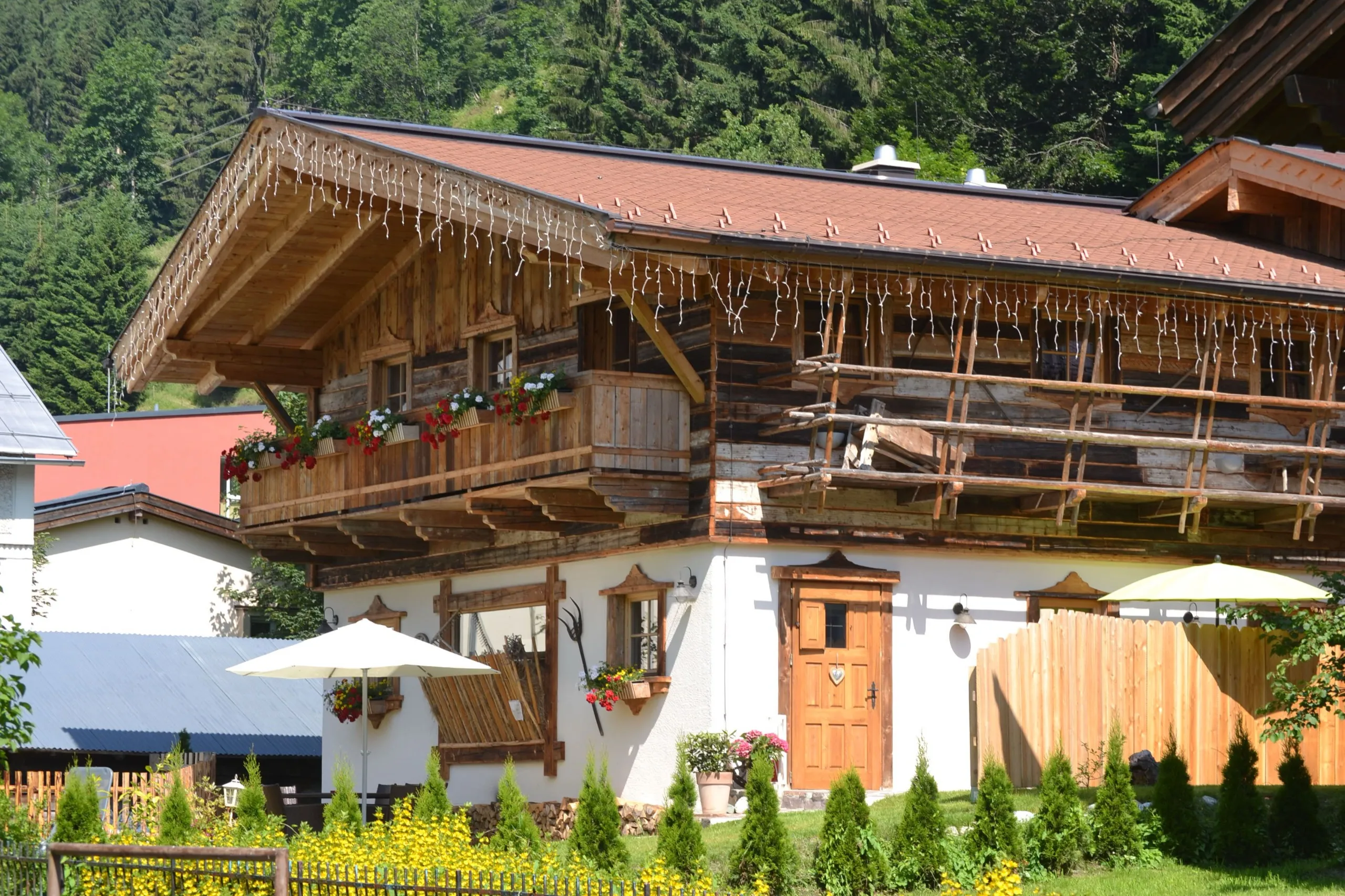 Almchalet am Hochkönig mit Blumenbalkon und Holzfassade an einem Sommertag