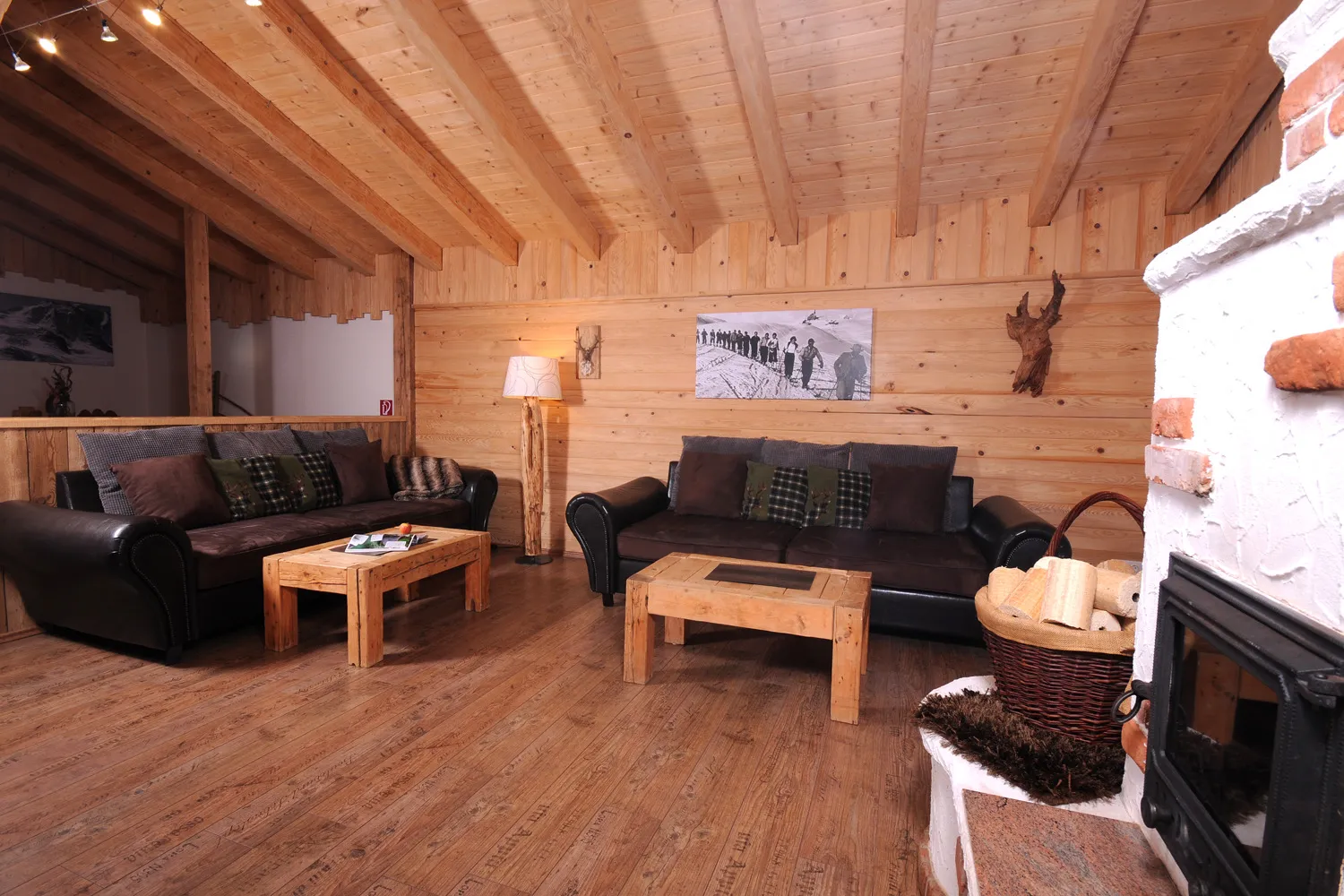 Wohnstube mit zwei Ledersofas und Kachelofen im Almchalet Schneeberg
